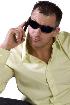 Man In Trendy Outfit With Sunglasses Talking On Cell Phone