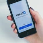 woman holding phone showing linkedin app | How To Delete LinkedIn Account In Just A Few Easy Steps | how to delete linkedin account | how to delete your linkedin | Featured