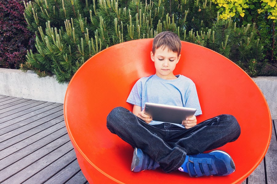 kid using tablet on a sunny day