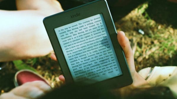 Feature | person reading kindle outdoor | Bestselling Amazon Kindle Books Of 2018