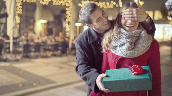 Feature | man keeping his girlfriends eyes close | Best Low-Priced Tech Gifts Anyone Will Love