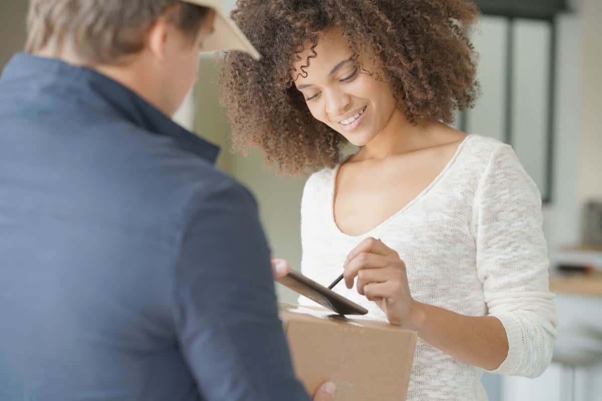 Mixed race woman receiving package from delivery man | Money-Making Side Hustles | Which One Is Best For You?
