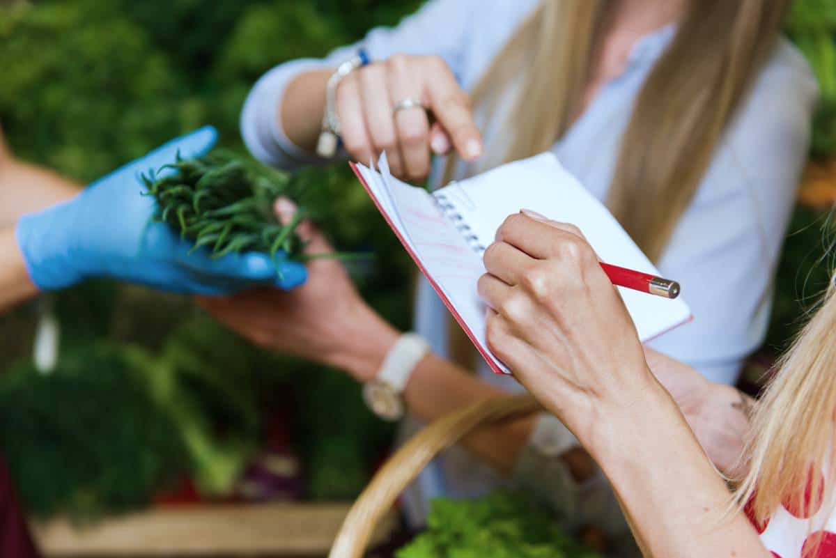 woman with shopping list | Smart Christmas Shopping Tips To Help You Stick To A Budget