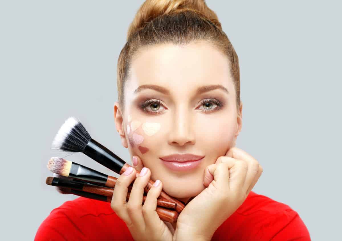 Beautiful woman holding makeup brush | There's An App For That | Phone Apps For Anything and Everything