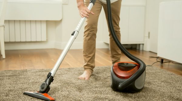 Man Vacuum cleaning the carpet | Top Gadgets To Speed Up Your Spring Cleaning