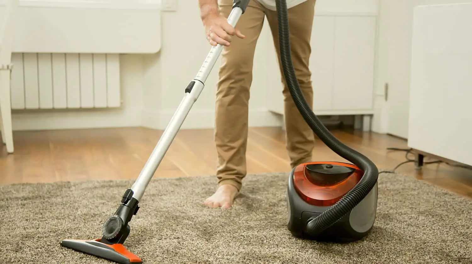Man Vacuum cleaning the carpet | Top Gadgets To Speed Up Your Spring Cleaning