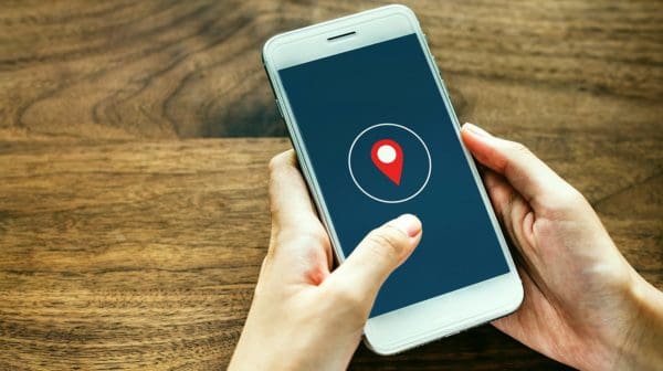 Feature | Holding smartphone showing location | Location Tracking On Smartphones: How Does It Work?