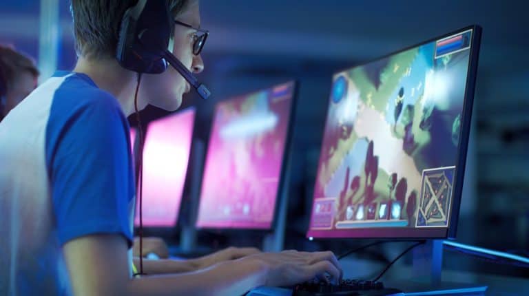 Feature | Young man wearing headset playing computer game | Best Graphics Cards For Gaming