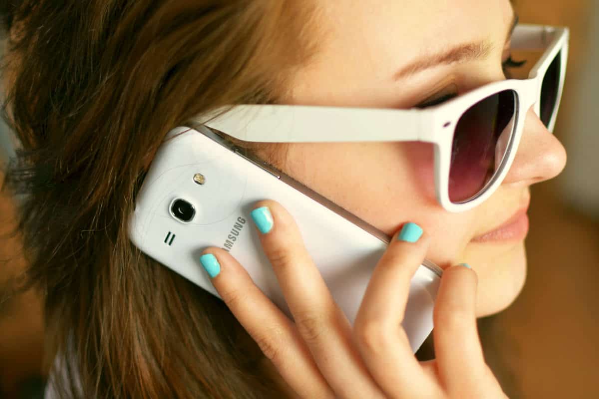 Person wearing sunglasses using smartphone | Cell Phone Rudeness Is Never Pretty | Ways You Are Being Rude With Your Cell Phone | rude cell phone manners