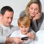Feature | Family playing video game on smart phone | Reasons To Monitor Your Kid's Cell Phone Use