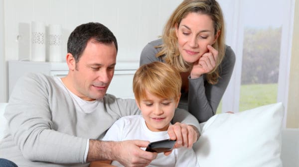 Feature | Family playing video game on smart phone | Reasons To Monitor Your Kid's Cell Phone Use