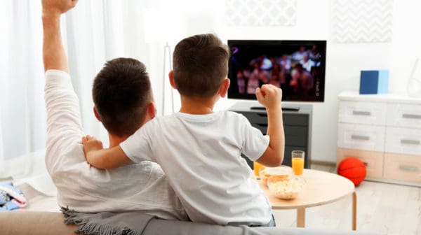 Feature | Father and son watching television at home | Xfinity Compatible Modems You Can Buy On Amazon