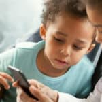 Interested African American children using smartphone together | Best Phones For Kids | emergency cell phones for kids | Featured