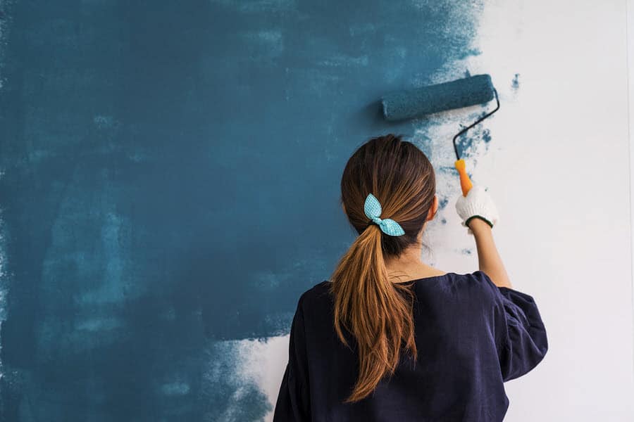 Woman painting interior wall