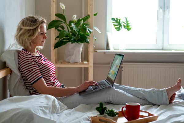 Woman on bed learning on laptop